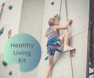 a girl with braided pig tails and climbing harness scaling an indoor rock climbing wall